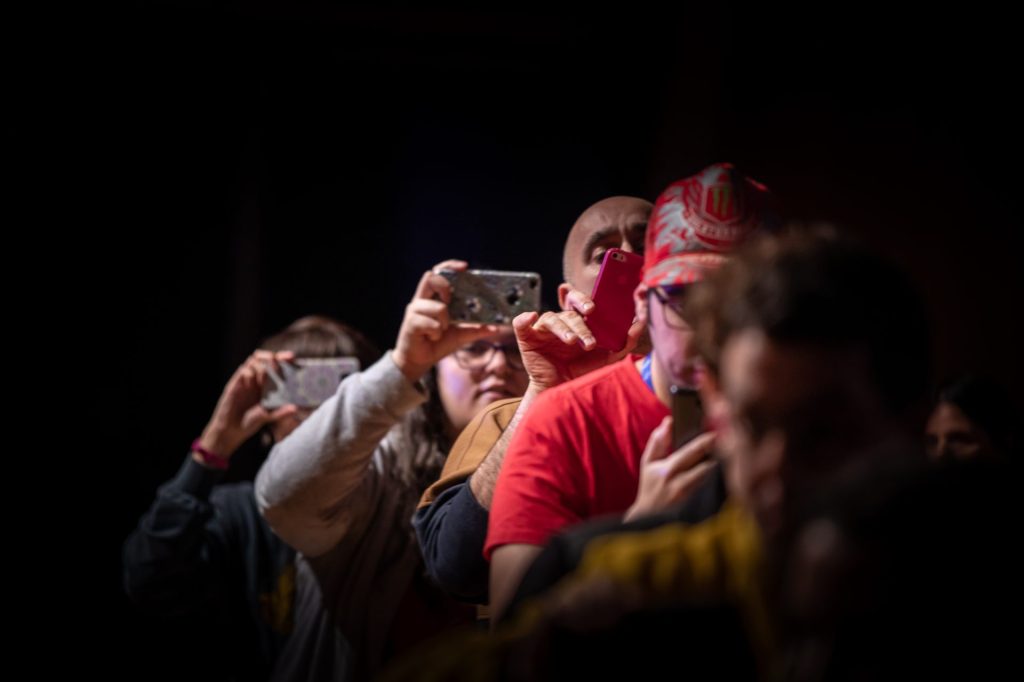 Grupo de personas en fila con móvil en la mano